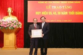 Ông Nguyễn Văn Nên trao huy hiệu 55 năm tuổi Đảng cho ông Phan Diễn, nguyên Ủy viên Bộ Chính trị khóa VIII và IX. (Ảnh: Phương Hoa/TTXVN)