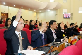 Các đại biểu thông qua Nghị quyết thu phí tham quan khu di tích Yên Tử từ 1/1/2018. (Ảnh: Văn Đức/TTXVN)