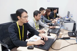 Phóng viên, biên tập viên Thông tấn xã Việt Nam tác nghiệp tại Trung tâm báo chí Quốc tế. (Ảnh: TTXVN)