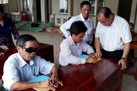 Dạy cho người mù học chữ nổi. (Ảnh: K GỬIH/TTXVN)