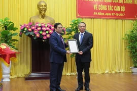 Ông Phạm Minh Chính, Ủy viên Bộ Chính trị, Trưởng Ban Tổ chức Trung ương trao quyết định cho ông Trương Quang Nghĩa. (Ảnh: Văn Sơn/TTXVN)