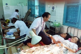  Các bác sỹ tập trung cấp cứu cho các học sinh bị ngộ độc thực phẩm. (Ảnh: Công Thử/TTXVN)