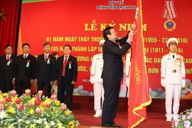 Chủ tịch nước Trương Tấn Sang gắn Huân chương Độc Lập hạng Ba lên lá cờ truyền thống của Bệnh viện Bạch Mai. (Ảnh: Nguyễn Khang/TTXVN)