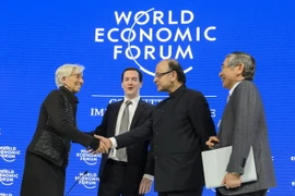 Trong ảnh (từ trái sang): Giám đốc IMF Christine Lagarde bắt tay Bộ trưởng Tài chính Ấn Độ Arun Jaitley và Thống đốc Ngân hàng Trung ương Nhật Bản Japan Haruhiko Kuroda sau phiên họp ở Davos ngày 23/1. (AFP/ TTXVN)