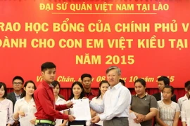 Đại sứ Nguyễn Mạnh Hùng trao quyết định học bổng cho học sinh Việt kiều. (Ảnh: Phạm Kiên/TTXVN) 