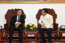 Tổng Giám đốc TTXVN Nguyễn Đức Lợi cùng Ủy viên Bộ Chính trị, Phó Thủ tướng Chính phủ Lào Phankham Viphavan. (Ảnh: Phạm Kiên/TTXVN)