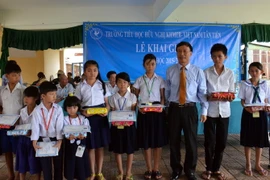 Ông Sum Chi, Chủ tịch Tổng hội người Campuchia gốc Việt Nam, trao tặng phần thưởng cho các học sinh đạt thành tích xuất sắc trong năm học 2014-2015. (Ảnh: Xuân Khu/TTXVN) 