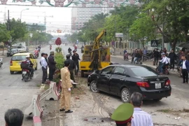 Tai nạn xảy ra khi chiếc xe bị mất lái đâm vào dải phân cách, hất văng một số cột, trụ của dải phân cách và lật ngửa giữa đường. (Ảnh: Xuân Tiến/TTXVN)