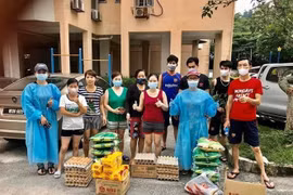 Đại diện Ban liên lạc và Câu lạc bộ Phụ nữ Việt Nam tại Malaysia (hai người mặc áo bảo hộ màu xanh) trao quà hỗ trợ đến bà con gặp khó khăn. (Ảnh: Hoàng Đình Nhương/TTXVN)