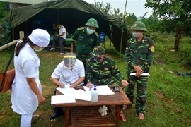 Đồn Biên phòng cửa khẩu A Đớt bàn giao công dân cho Trung tâm y tế huyện A Lưới. (Ảnh: TTXVN phát)