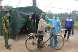 Các lực lượng chức năng Hà Nam đo thân nhiệt của người dân. (Ảnh: Thanh Tuấn/TTXVN)