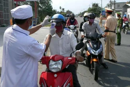 Đo thân nhiệt người vào cửa ngõ Sóc Trăng. (Ảnh: TTXN/phát)