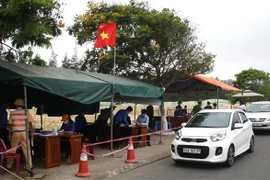 Các đoàn viên thanh niên tham gia hỗ trợ các lực lượng chức năg tại chốt kiểm soát trên tuyến đường ven biển tỉnh Quảng Nam tiếp giáp với thành phố Đà Nẵng. (Ảnh: Trịnh Bang Nhiệm/TTXVN)