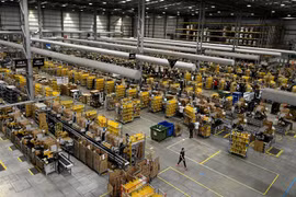 Nhân viên đóng gói hàng hóa cho khách hàng tại một trung tâm dịch vụ của Amazon. (Ảnh: AFP/TTXVN)