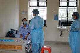 Nhân viên y tế thăm hỏi tình hình sức khỏe người cách ly tại khu cách ly Trung tâm Quận 2. (Ảnh: Đinh Hằng/TTXVN)