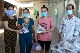 Đại diện khu phố trao những suất cơm nghĩa tình công nhân đến tận tay người lao động có hoàn cảnh khó khăn tại các khu trọ. (Ảnh: Thanh Vũ/TTXVN)