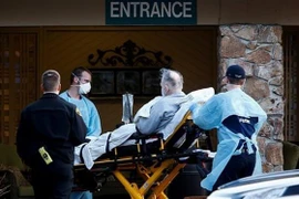 Nhân viên y tế chuyển bệnh nhân nhiễm COVD-19 lên xe cứu thương tại viện dưỡng lão Life Care Center ở Kirkland, bang Washington, Mỹ. (Ảnh: Reuters/TTXVN)