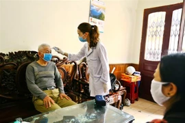 Nhân viên y tế tại Quảng Ninh đo thân nhiệt, khám sức khỏe cho người cao tuổi. (Ảnh: Minh Quyết/TTXVN)