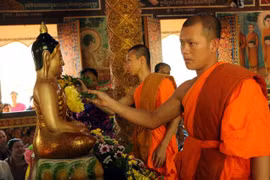 Các sư sãi thực hiện nghi thức tắm Phật tại chùa Khmer. (Ảnh: Trung Hiếu/TTXVN)
