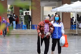 Người nghèo, người có hoàn cảnh khó khăn bị ảnh hưởng bởi dịch COVID-19 nhận quà trong sáng 25/4. (Ảnh: Thanh Tùng/TTXVN)