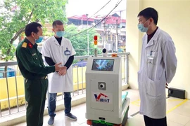 Đại diện Học viện kỹ thuật quân sự giới thiệu robot với các bác sỹ bệnh viện Bắc Thăng Long. (Ảnh: TTXVN phát)