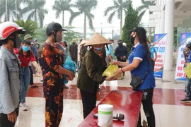 Phát gạo cho người dân gặp khó khăn do dịch COVID-19. (Ảnh: Hoàng Ngà/TTXVN)