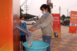 Công nhân lấy gạo miễn phí tại cây ATM gạo tại Khu công nghiệp Quế Võ, tỉnh Bắc Ninh. (Ảnh: Thái Hùng/TTXVN)