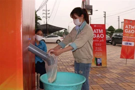 Công nhân lấy gạo miễn phí tại cây ATM gạo tại Khu công nghiệp Quế Võ, tỉnh Bắc Ninh. (Ảnh: Thái Hùng/TTXVN)