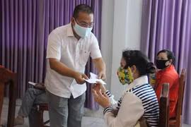 Ông Võ Tuấn Ngọc, Lãnh đạo Tổ Công tác cộng đồng Đại sứ quán Việt Nam, trao hàng cứu trợ cho bà con gốc Việt tại Campuchia. (Ảnh: TTXVN/phát)