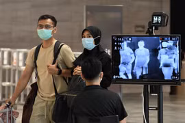 Hành khách đeo khẩu trang để phòng tránh lây nhiễm COVID-19 tại sân bay quốc tế Changi, Singapore. (Ảnh: AFP/TTXVN)