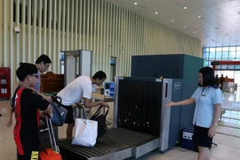 Nhân viên Chi cục Hải quan cửa khẩu quốc tế Hữu Nghị (Lạng Sơn) giám sát việc kiểm tra hành lý của khách nhập cảnh bằng máy soi. (Ảnh: Phạm Hậu/TTXVN)