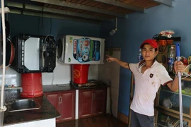 Người dân dọn nhà cửa sau khi nước rút. (Ảnh: K GỬIH/TTXVN)