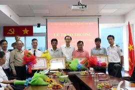 Ông Lê Thanh Liêm, Phó Chủ tịch Thường trực UBND Thành phố Hồ Chí Minh trao Bằng khen cho các cá nhân có thành tích xuất sắc trong công tác cứu hộ, cứu nạn. (Ảnh: Xuân Khu/TTXVN)
