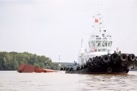 Phương tiện lai dắt container vào tập kết gần bờ, tạo thông thoáng cho lòng sông Lòng Tàu. (Ảnh: Tiến Lực/TTXVN)