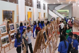 Các đại biểu xem ảnh tại triển lãm. (Ảnh: Tiên Minh/TTXVN)