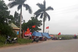 Người dân dựng lán trại ở cổng ra vào Công ty cổ phần gốm xây dựng Đại Thắng. (Ảnh: Thế Duyệt/TTXVN)