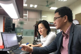 Tiến sỹ Kiều Hà trao đổi công việc với đồng nghiệp.