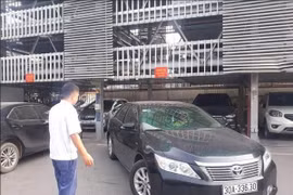 Nhân viên điểm trông giữ xe của Công Ty TNHH Một Thành Viên Khai Thác Điểm Đỗ Xe Hà Nội hướng dẫn xe ra vào điểm đỗ xe lắp ghép. (Ảnh: Tuyết Mai/TTXVN)