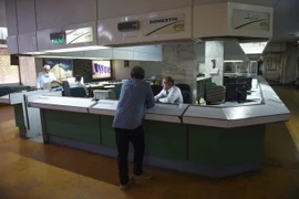 Nhân viên Hãng hàng không quốc tế Pakistan giao dịch với hành khách. (Ảnh: AFP/TTXVN)