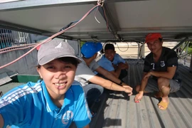 Nguyễn Thị Thùy Linh trong một lần khảo sát lắp đặt hệ thống điện năng lượng mặt trời áp mái. (Ảnh TTXVN phát)