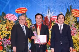 Đại diện Hội đồng chức danh giáo sư Nhà nước trao chứng nhận cho các tân giáo sư, phó giáo sư. (Ảnh: Quý Trung/TTXVN)