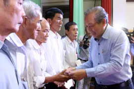 Phó Thủ tướng Thường trực Trương Hòa Bình trao quà cho các gia đình chính sách. (Ảnh: Trần Thị Thu Hiền/TTXVN)