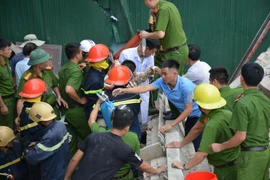 Lực lượng chức năng đưa người bị nạn đi cấp cứu. (Ảnh: Phan Quân/TTXVN)