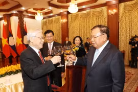 Tổng Bí thư, Chủ tịch nước Lào Bounhang Volachith nâng cốc chúc mừng Tổng Bí thư, Chủ tịch nước Nguyễn Phú Trọng. (Ảnh: Trí Dũng/TTXVN)