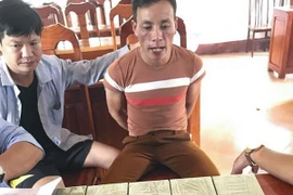 Đối tượng Phàn Vần Páo cùng tang vật tại cơ quan điều tra. (Ảnh: TTXVN phát)