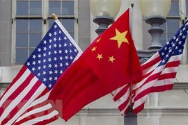 Quốc kỳ Trung Quốc (giữa) và quốc kỳ Mỹ. (Ảnh: Getty Images/TTXVN)