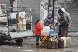 Người dân mua xăng dầu trên phố ở tỉnh Idlib, Syria. (Ảnh: AFP/TTXVN)