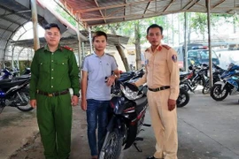 Anh Nguyễn Đăng Trình nhận lại xe tại cơ quan Công an. (Ảnh: Lê Đức Hoảnh/TTXVN)
