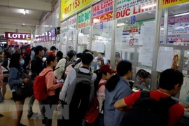 Hành khách mua vé về quê tại bến xe Miền Đông. (Ảnh: Hoàng Hải/TTXVN)
