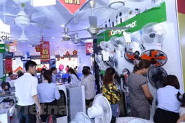 Người dân đi mua sắm các thiết bị chống nắng nóng. (Ảnh: Thanh Tâm/Vietnam+)
